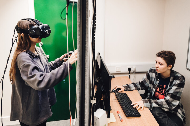A participant and researcher conducting a virtual reality experiment